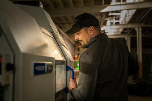 Craftsman operating precision machinery to create USA made EDC tools in a workshop setting