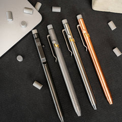 Set of four bolt action mechanical pencil pens by Big Idea Design LLC in various metallic finishes on a black surface