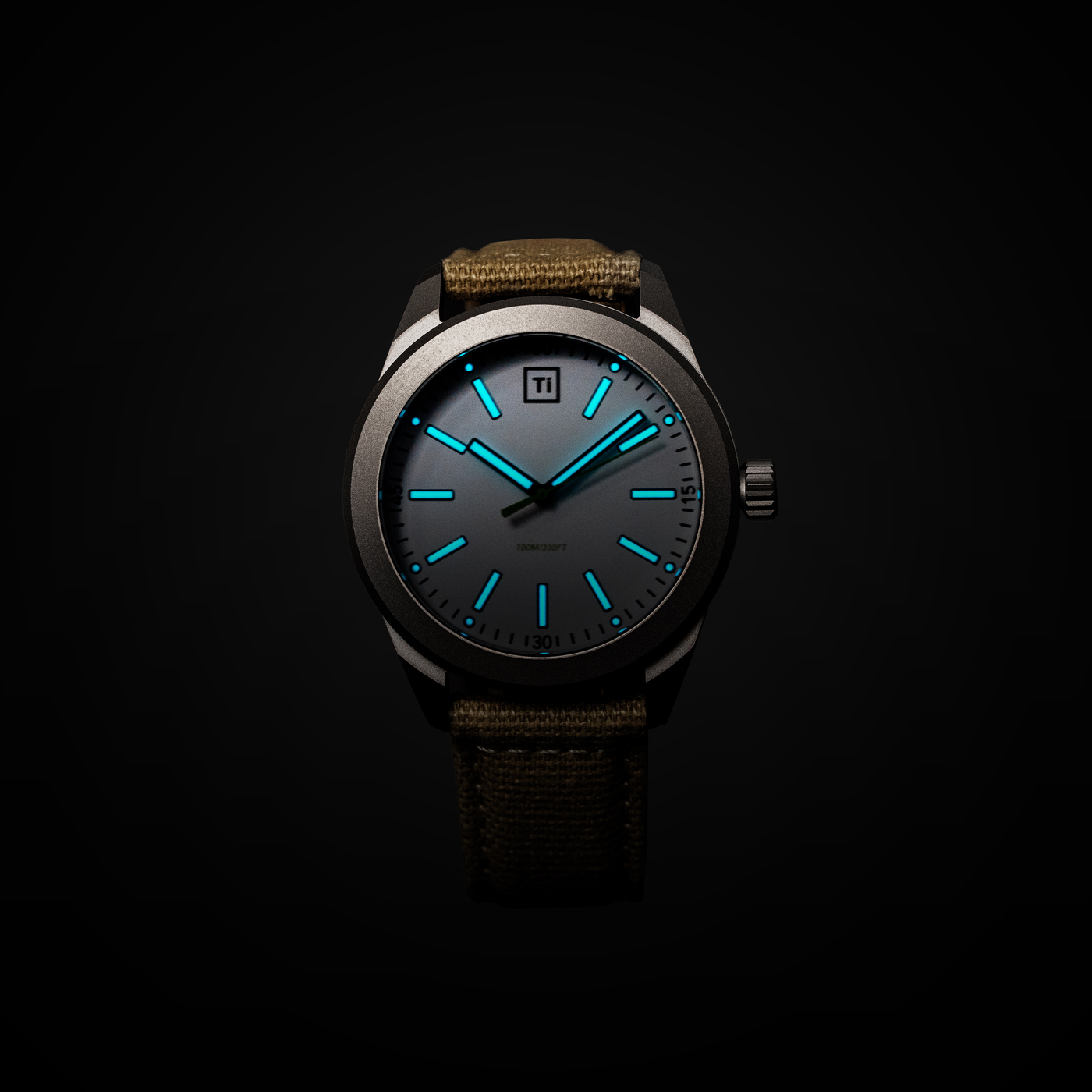 Big Idea Design LLC titanium field watch with luminous blue hands and markers dark dial titanium case canvas strap