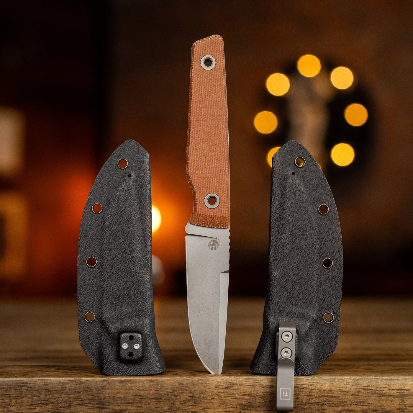 BIGiDESIGN-USA fixed blad knife with brown handle and black sheath on wooden surface