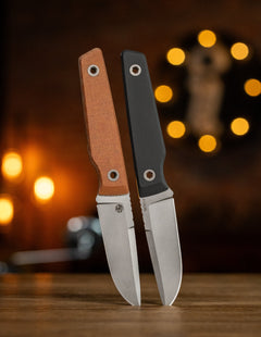 BIGiDESIGN-USA fixed blad knives with brown and black handles standing on wooden surface with blurred background