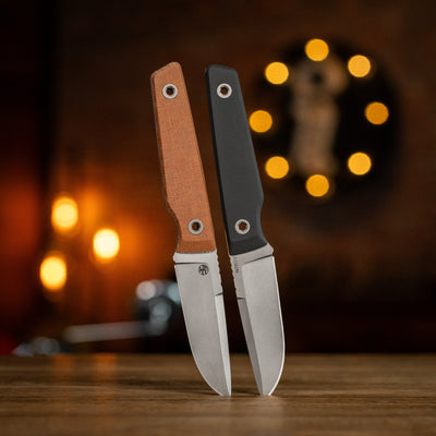 BIGiDESIGN-USA fixed blad knives with brown and black handles standing on wooden surface with blurred background