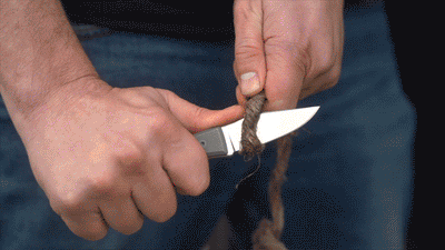 BIG IDEA DESIGN LLC titanium fixed blade knife cutting rope in hand showing sharp drop point blade