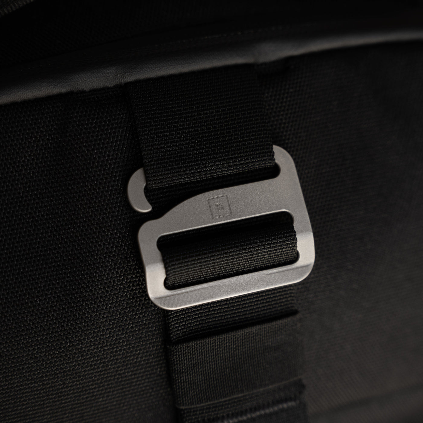 Close-up of black strap and metal buckle detail on Big Idea Design LLC everyday carry backpack