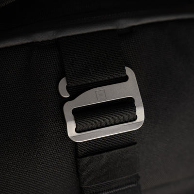 Close-up of black strap and metal buckle detail on Big Idea Design LLC everyday carry backpack