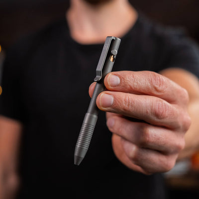 USA Bolt Action Pen in gray metal finish held by a person with a black shirt