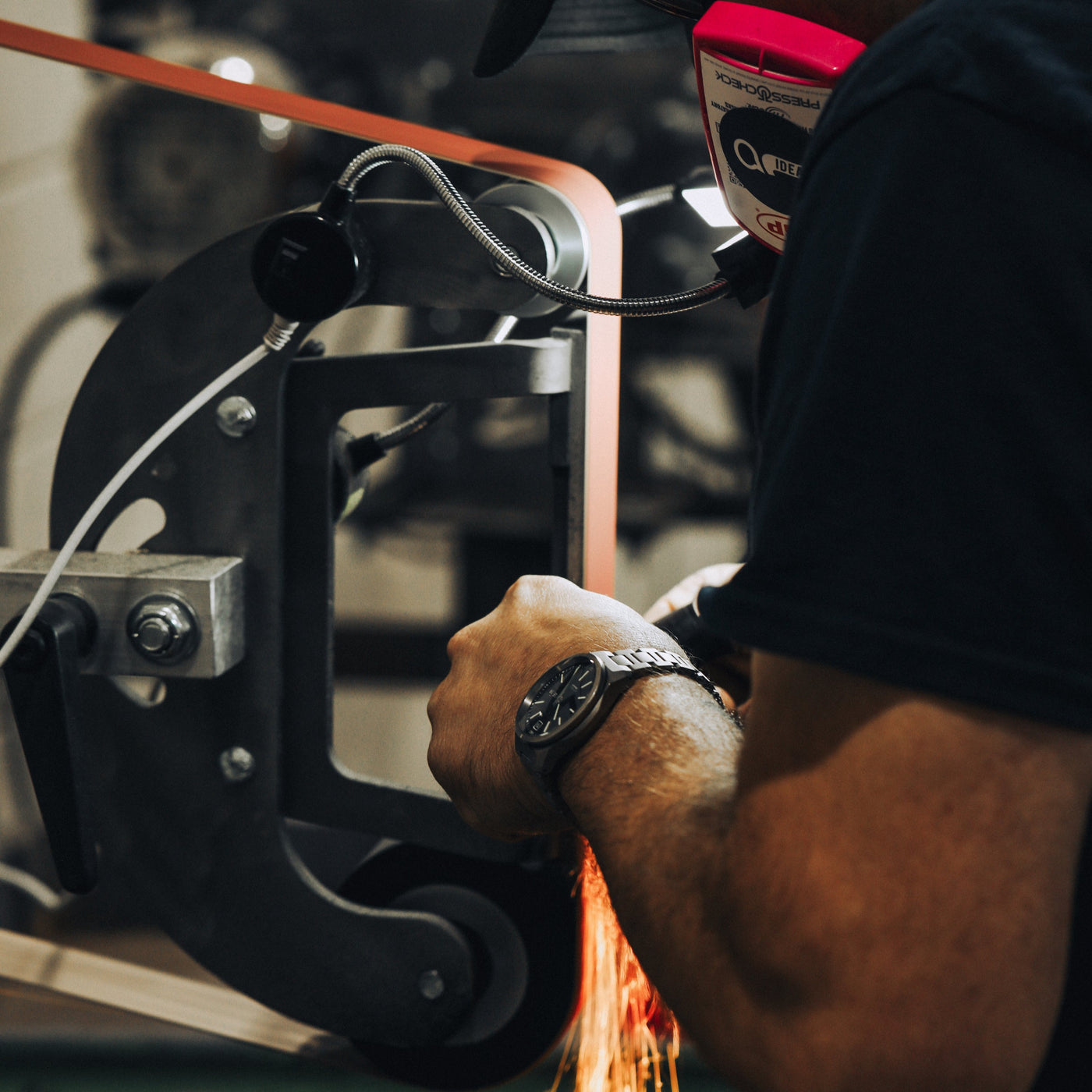 Craftsman sharpening the USA Lookout Fixed Blade knife with precision on a grinding machine