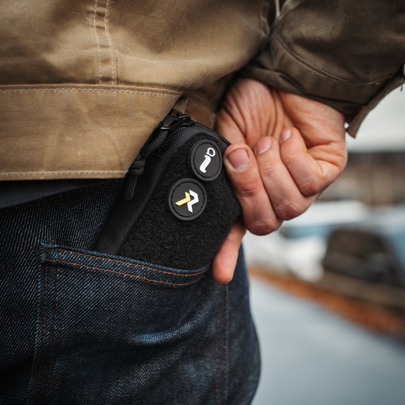 Black EDC pocket pouch by Big Idea Design LLC carried in back jeans pocket with zipper and patches