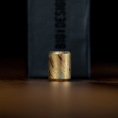 Damascus lanyard bead with intricate gold and silver layered patterns by Big Idea Design LLC