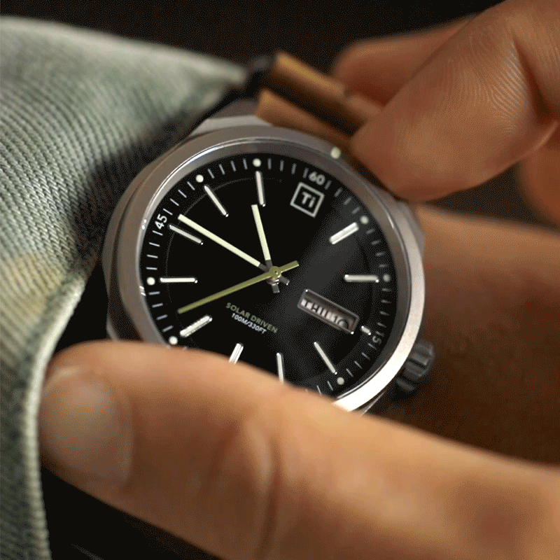 Solar titanium field watch with black dial and silver hands on wrist