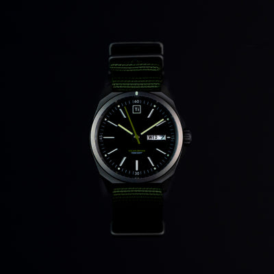 Solar titanium field watch by Big Idea Design LLC with black dial and green nylon strap