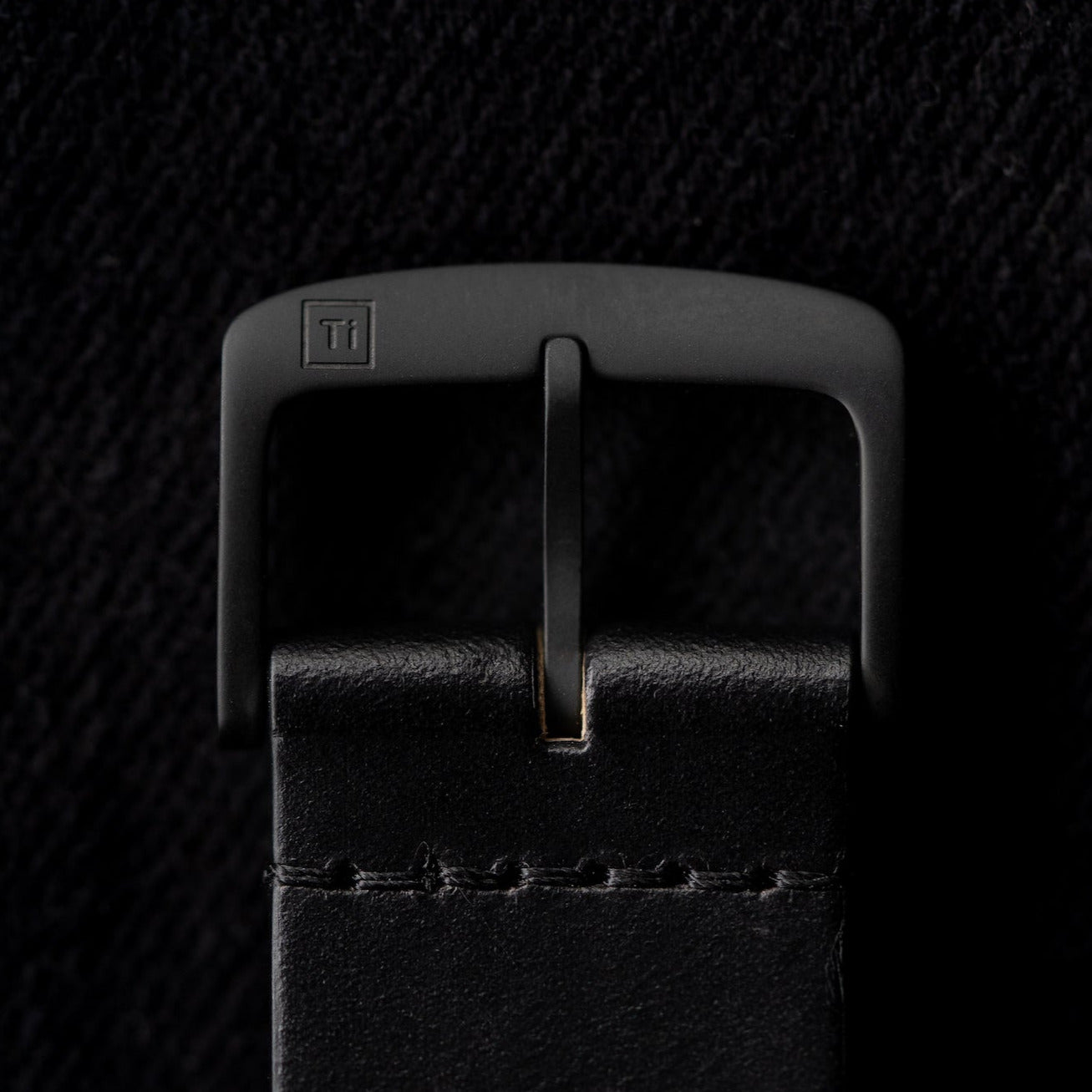 Close-up of black buckle detail on a solar powered titanium watch leather strap