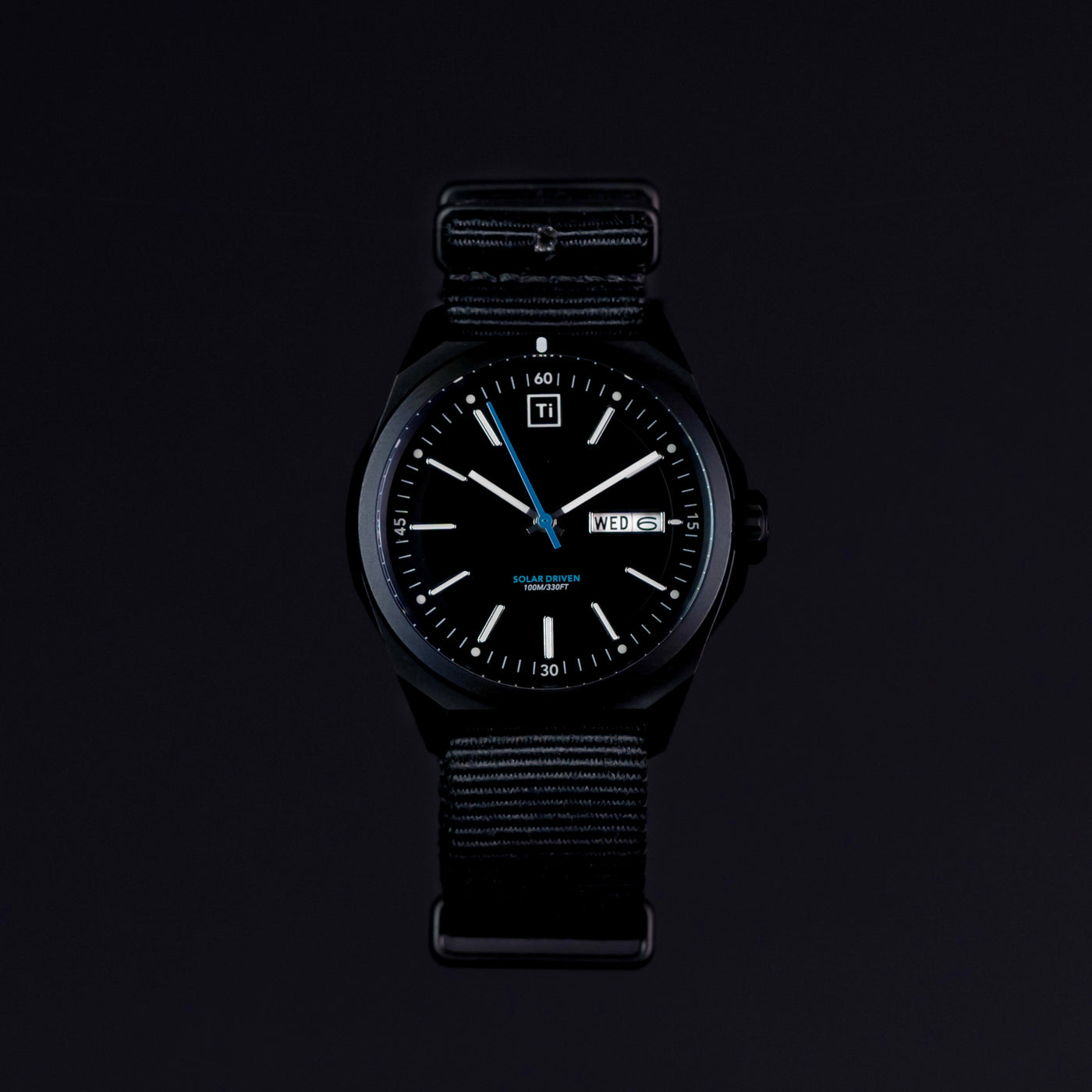 Black solar powered titanium watch with date display and black fabric strap by Big Idea Design LLC