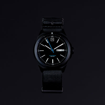 Black solar powered titanium watch with date display and black fabric strap by Big Idea Design LLC