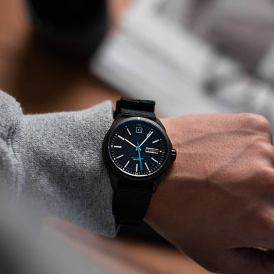 Big Idea Design LLC solar powered titanium watch with black dial and strap worn on wrist