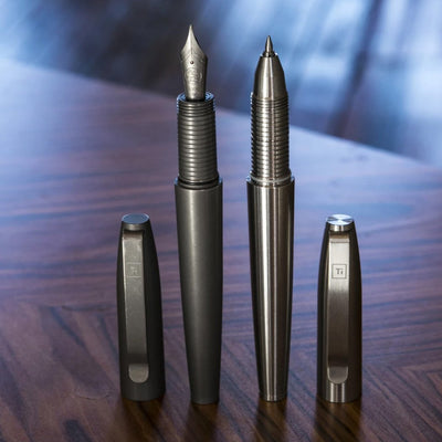 Big Idea Design LLC Titanium Fountain Pen and matching ballpoint pen with sleek metal finish on wooden table