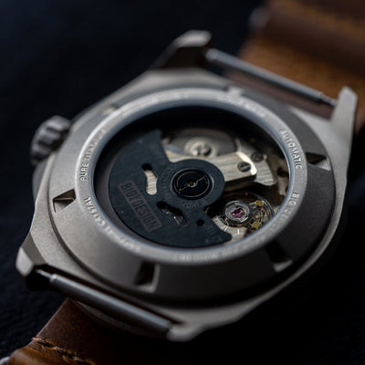 Close-up of the back case showing the mechanical movement of a titanium automatic field watch by Big Idea Design LLC