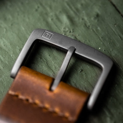 Close-up of titanium buckle on brown leather strap for titanium automatic field watch by Big Idea Design