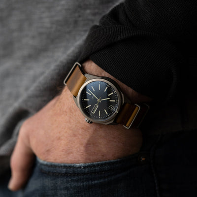 titanium automatic field watch with brown leather strap on wrist