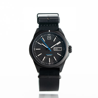 Big Idea Design LLC titanium automatic watch with black dial and leather strap showing date and day