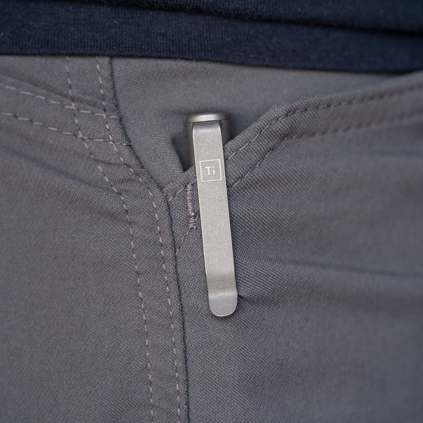Titanium bolt action pen clipped to the pocket of gray pants by Big Idea Design LLC