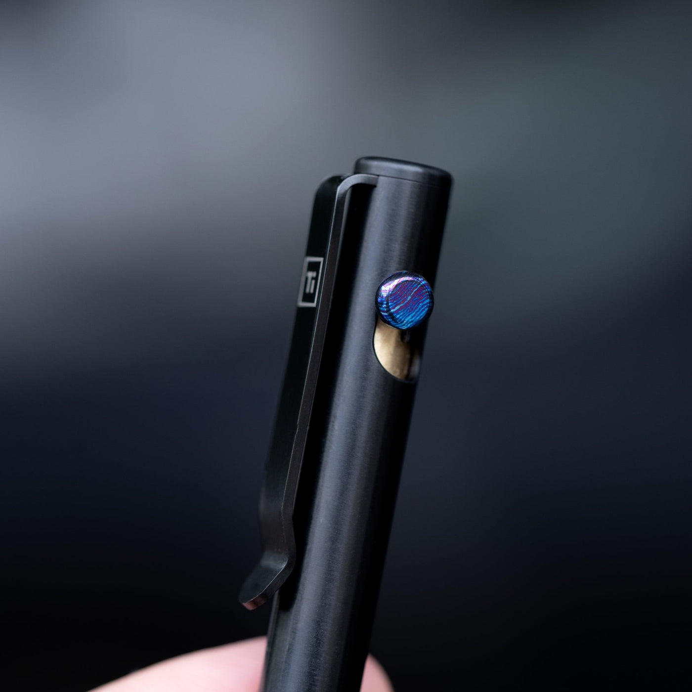 Black titanium bolt action pen by Big Idea Design LLC with blue textured bolt and clip