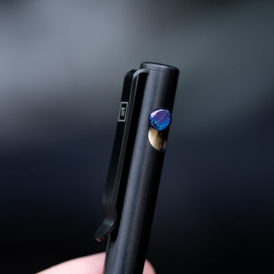 Black titanium bolt action pen by Big Idea Design LLC with blue textured bolt and clip