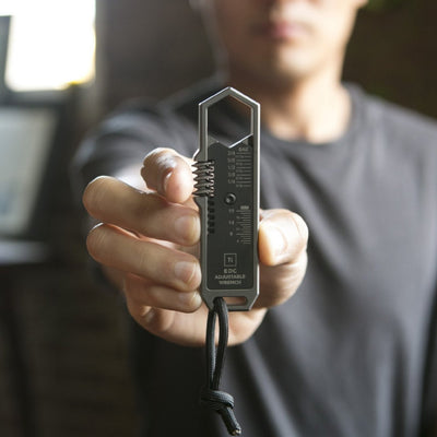 Person holding a BIG IDEA DESIGN LLC titanium EDC wrench with adjustable sizes and keychain loop