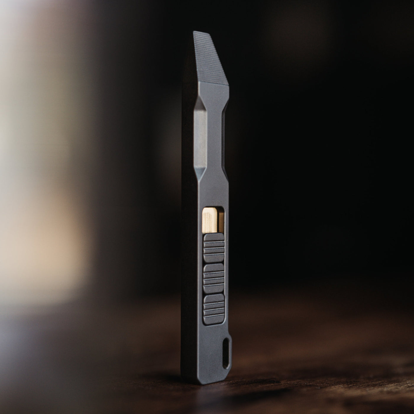 Sleek black titanium pry bar tool with textured grip and angled tip for precision prying tasks