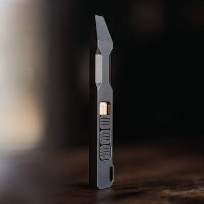 Sleek black titanium pry bar tool with textured grip and angled tip for precision prying tasks
