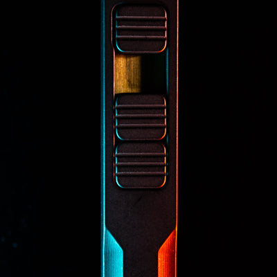 Close-up of titanium pry bar tool by Big Idea Design LLC with textured grip and sleek black finish